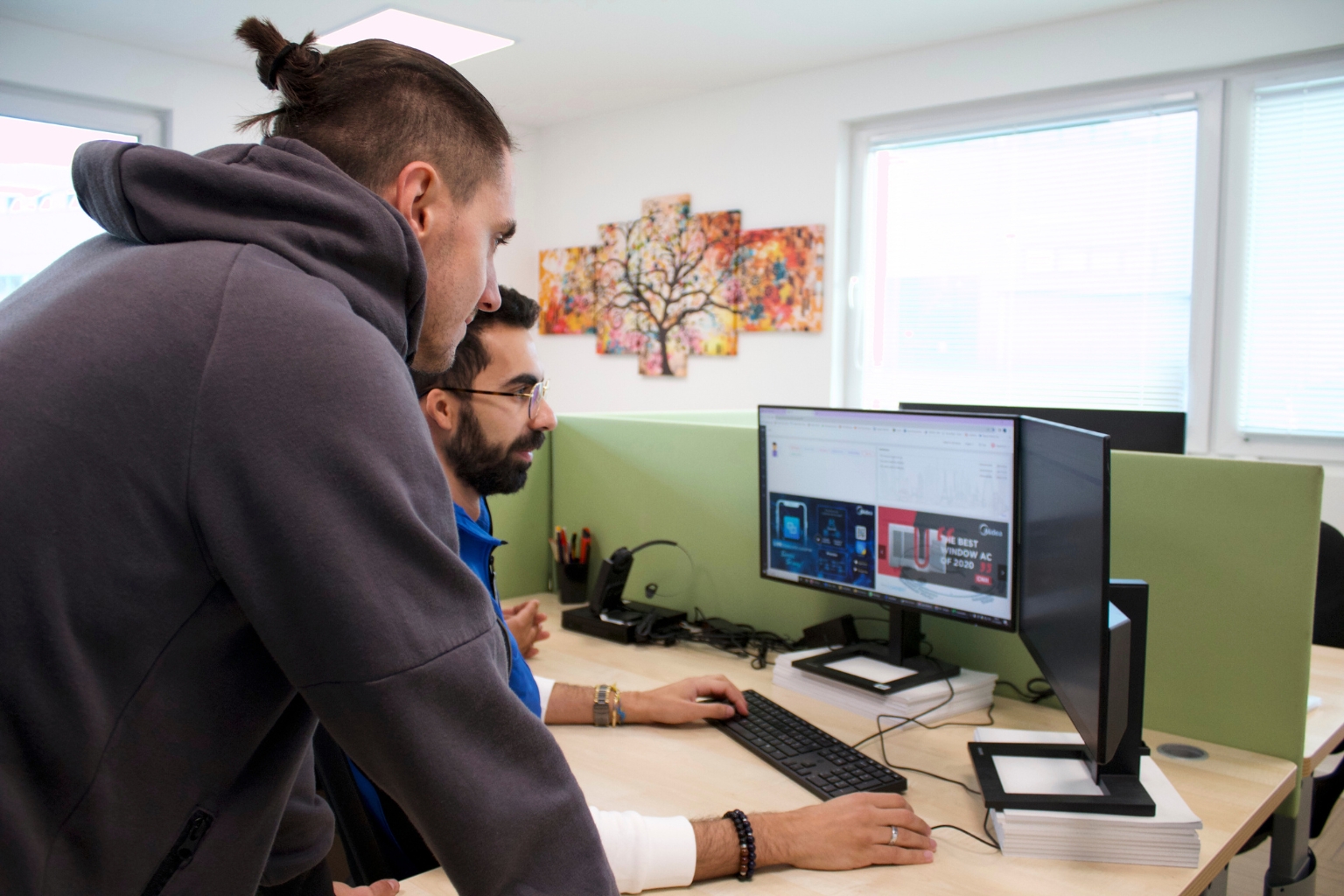 Due tecnici osservano un climatizzatore sullo schermo del computer in ufficio