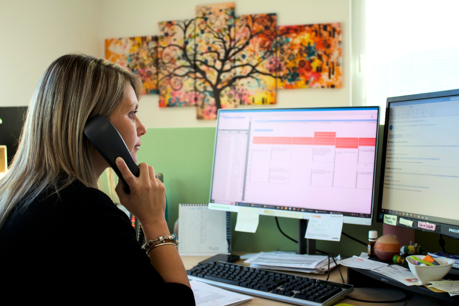 Donna al telefono alla scrivania in ufficio